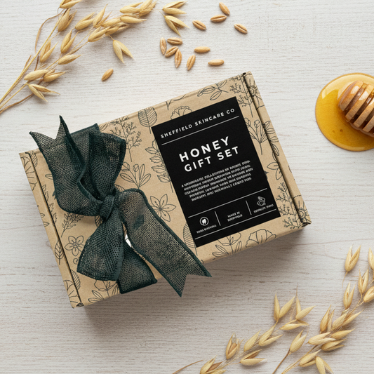 Sheffield Skincare Co. Honey Gift Set with a green ribbon on a light wooden surface.